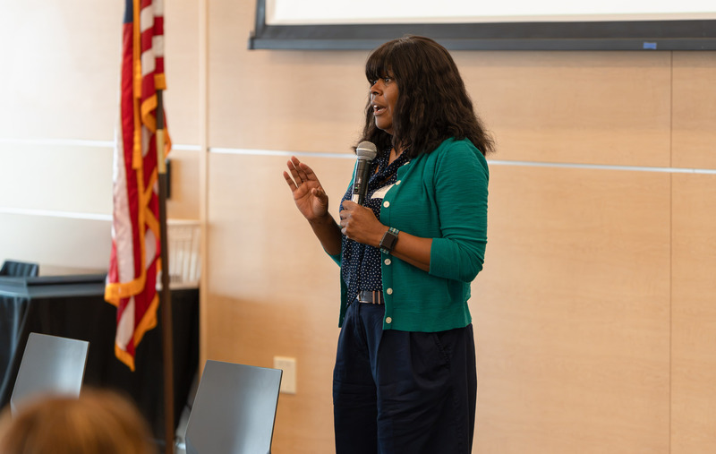 African American woman talking with microphone at front of room