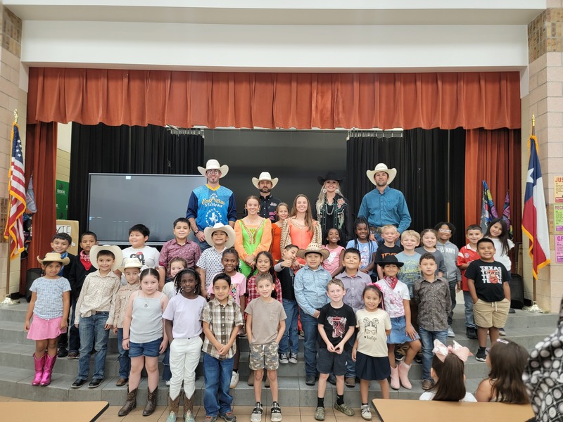 Group of students standing with Cowboys and performers for photo