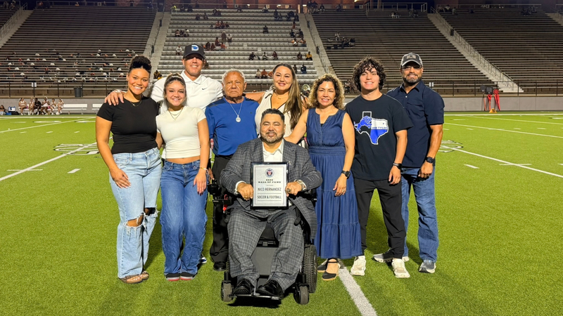 Nico Hernandez holding Hall of Fame plaque with family
