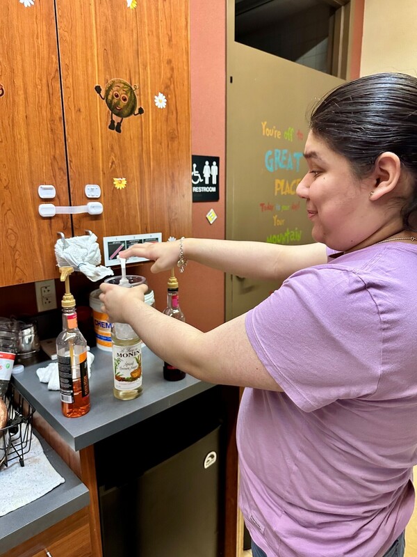 teen girl adding syrup from bottle with pump on counter