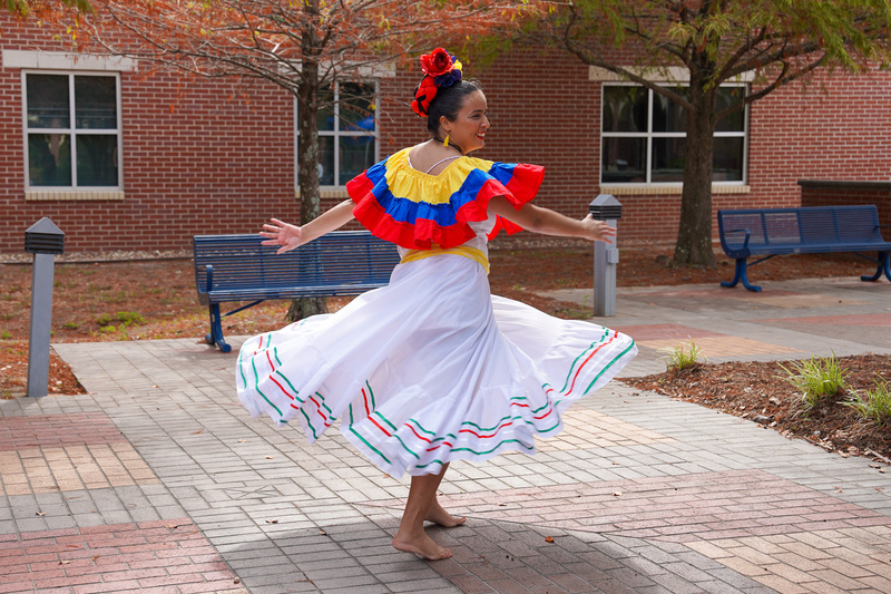 woman in traditional Hispanic dress dancing on bricks in a courtyard