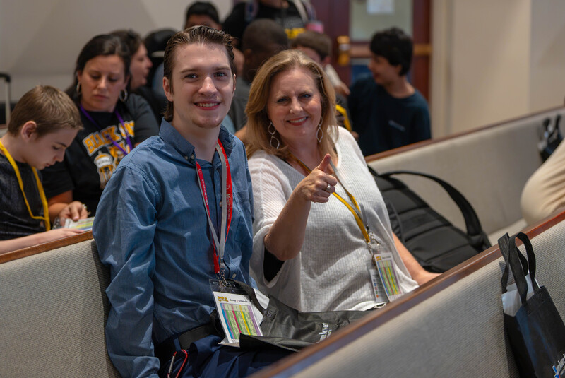 teen boy and woman sitting in church pews