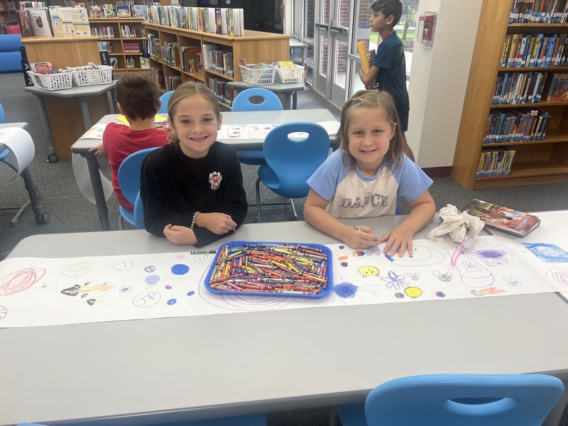 Students designing their dots on Dot Day in the library.