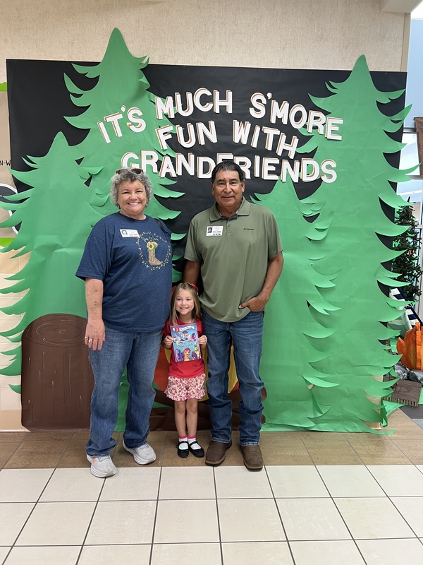 student with their grandfriends in front of the library decorations