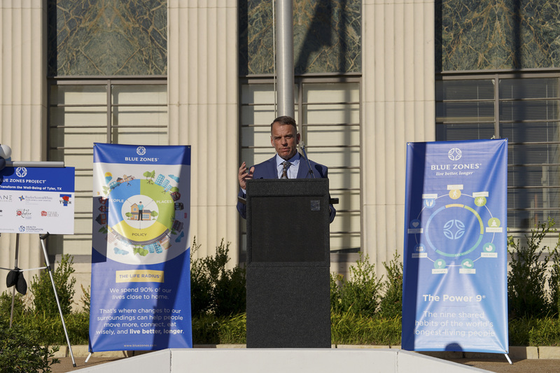 man standing at podium speaking to crowd
