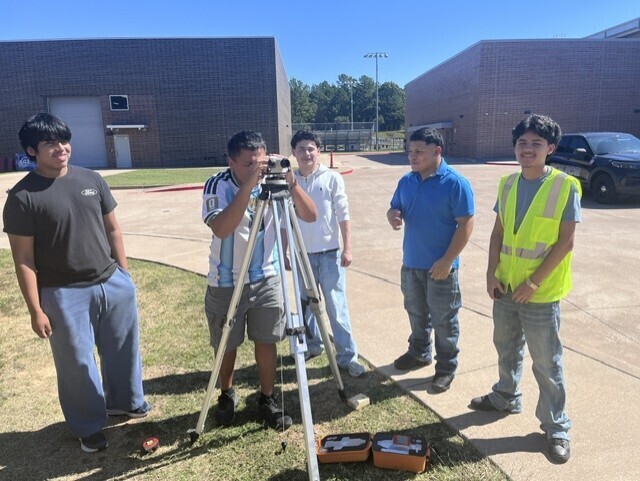 students using a tripod to survey a site
