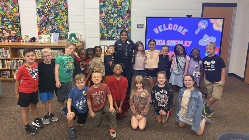 An officer spending time with students at Owens Elementary for Hispanic Heritage Month