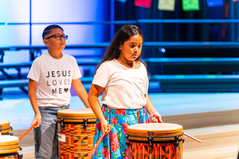 boy and girl playing drums on stage