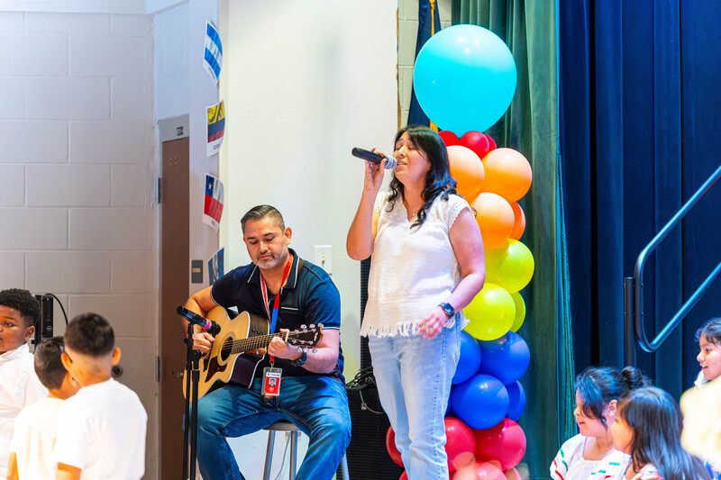 man playing guitar and woman singing on stage