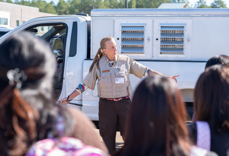 woman in front of animal control truck talking to high school students