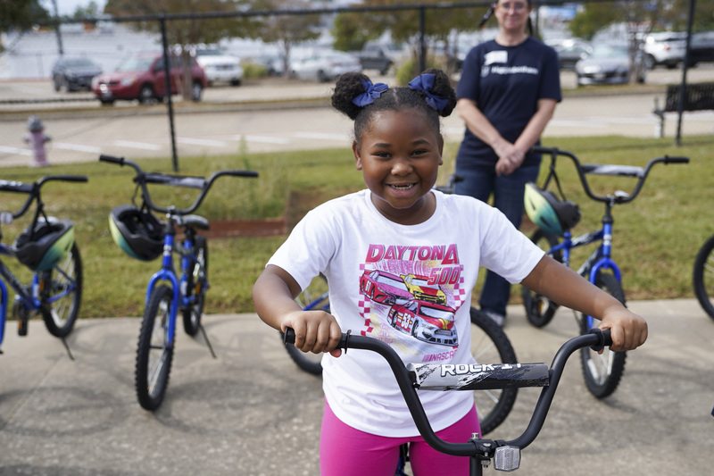 young girl standing next to her new bike