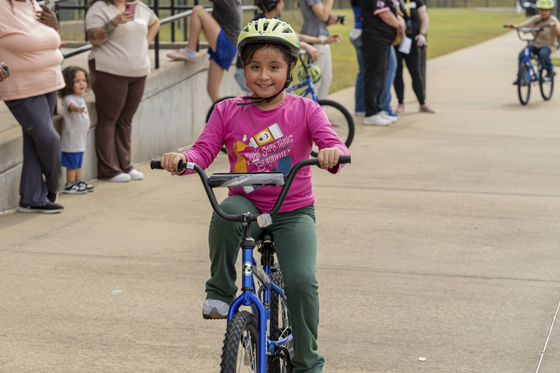young girl riding her new bike with helmet on