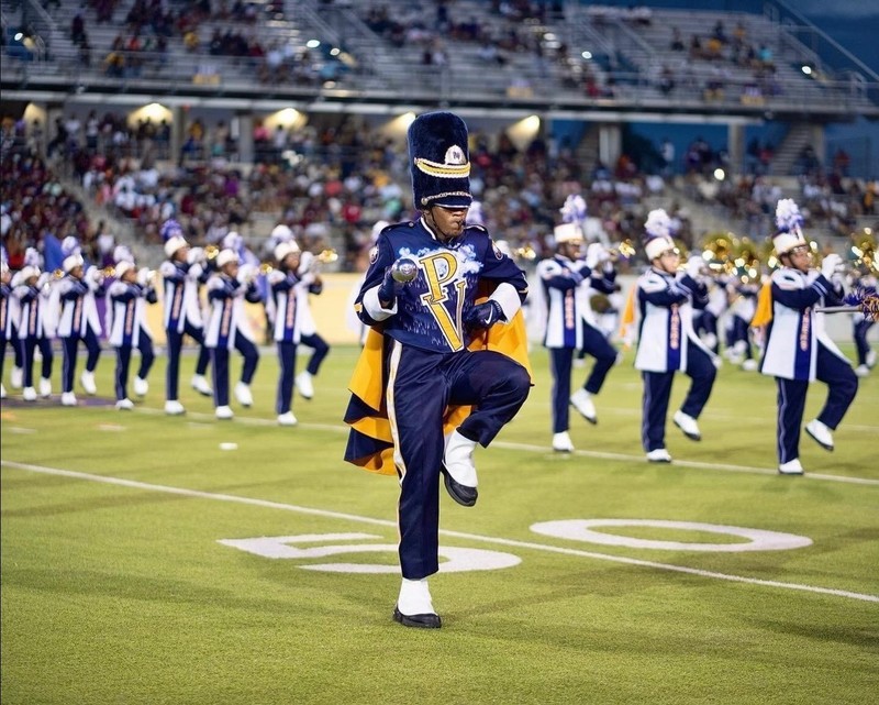 marching band on field in blue and yellow uniforms