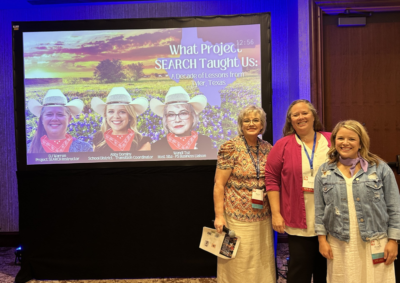 three women standing in front of projection screen 