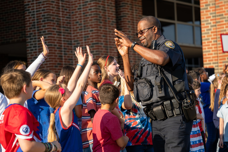 police officer high-fiving elementary students