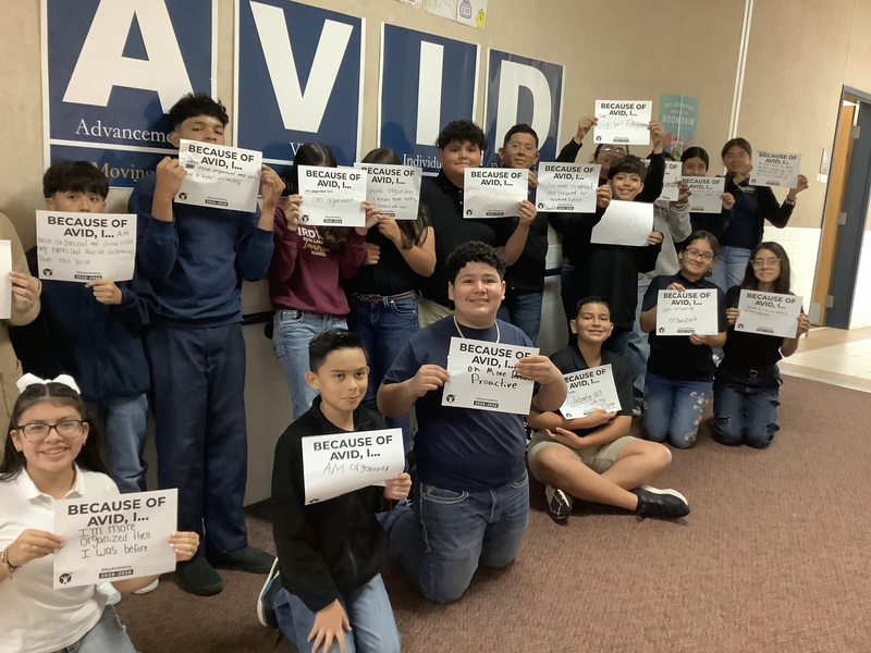group of middle school kids holding signs in a hallway