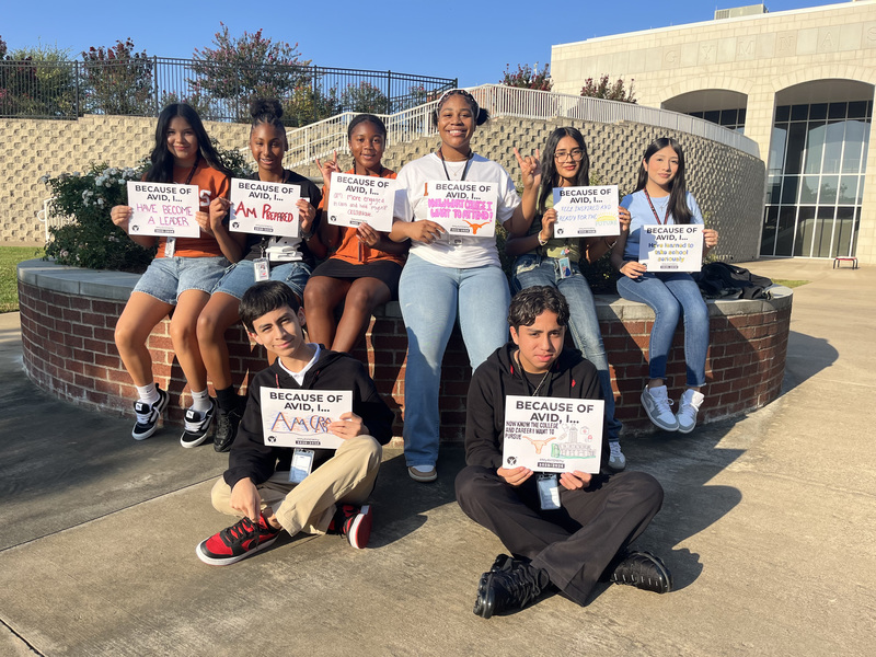middle school kids outside a school holding signs