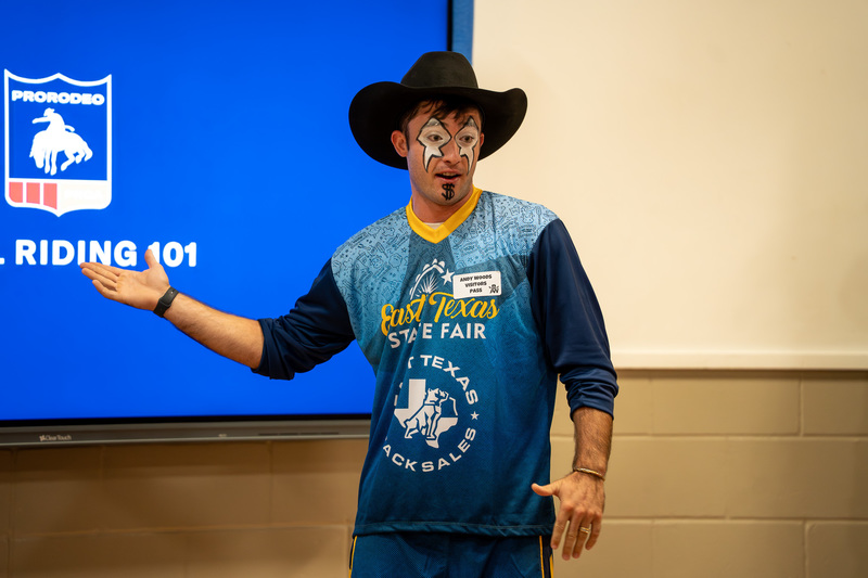 rodeo clown pointing at a video screen