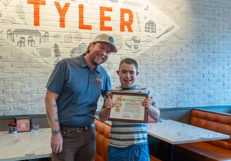 man next to teen boy holding a certificate