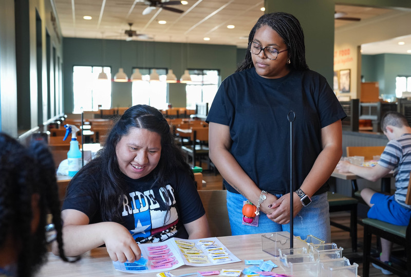 two women at a table sorting sugar packets