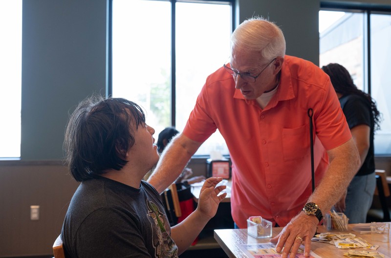 two men talking to each other at a table