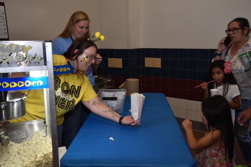 women passing out popcorn to kids