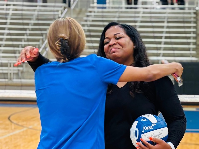 two women hugging each other in a gym
