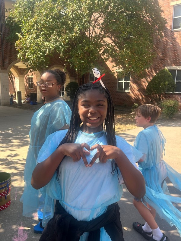 student makig a heart with her hands