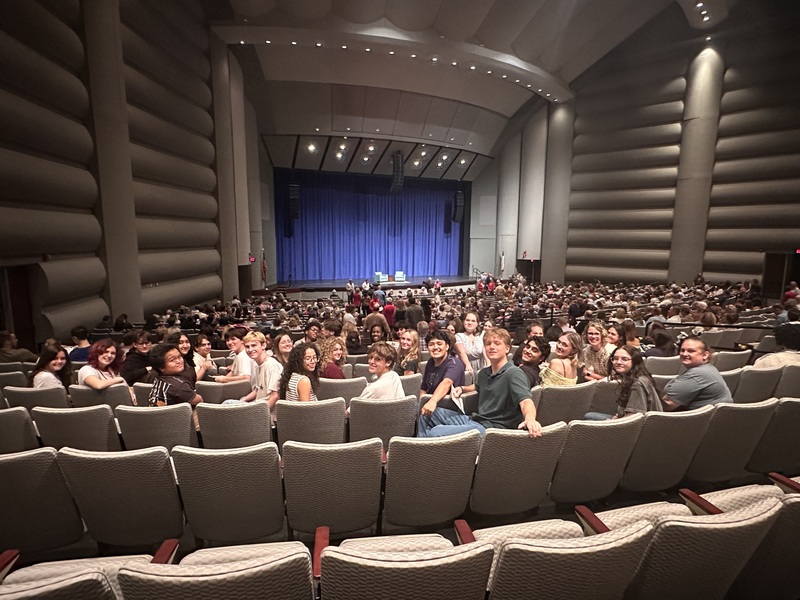 high school students in auditorium seating with stage behind them