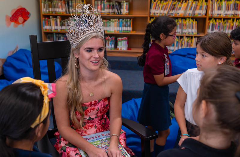 teen girl with crown talking to elementary age girls