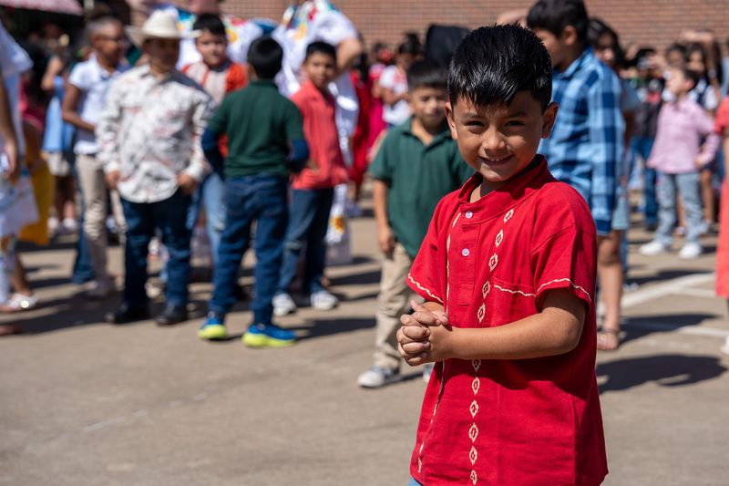 boy in red shirt standing in crowd