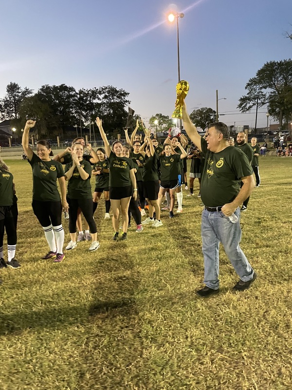 man holding trophy with adults around him