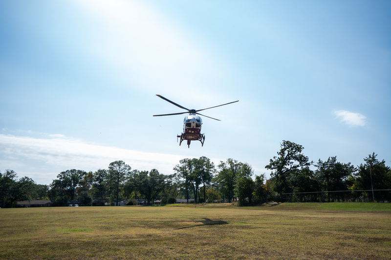 helicopter coming in for landing in grassy field