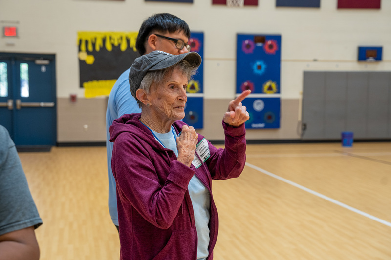 elderly woman in gym pointing