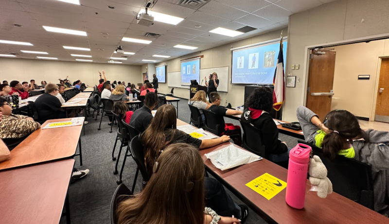 people sitting at tables in large room