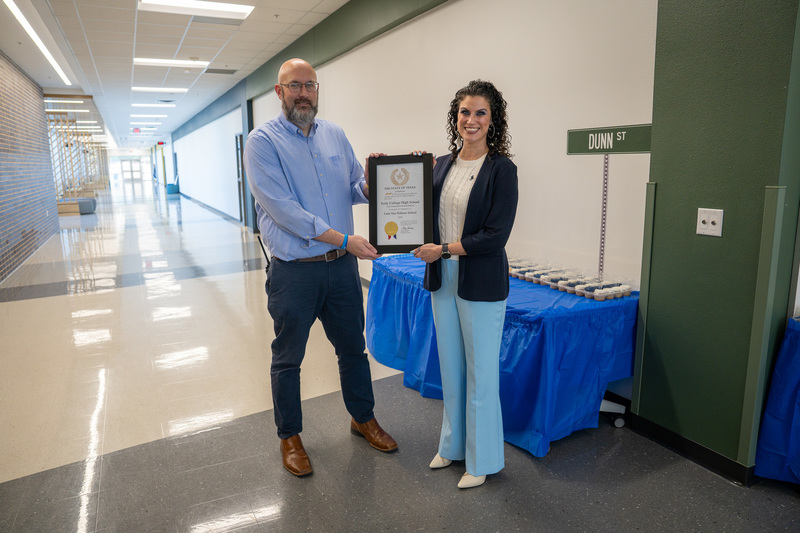 man and woman holding plaque