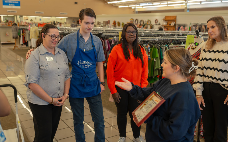 woman talking to group of people in store