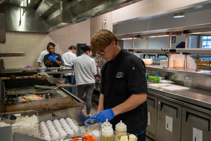 high school students preparing lunch in kitchen