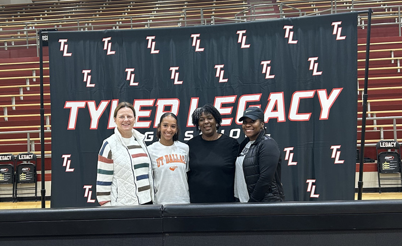 teen girl and three women stand in front of Tyler Legacy sign in gym