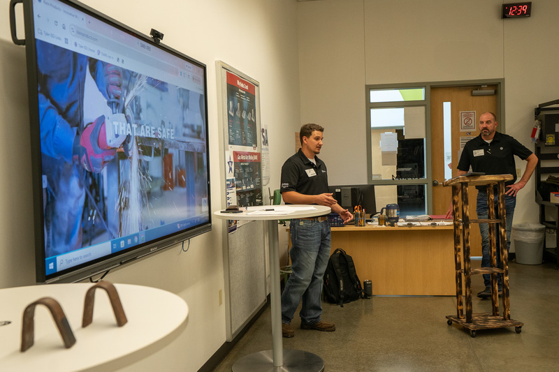two men talking to students in classroom