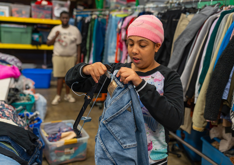 teen girl putting clothes on a hanger