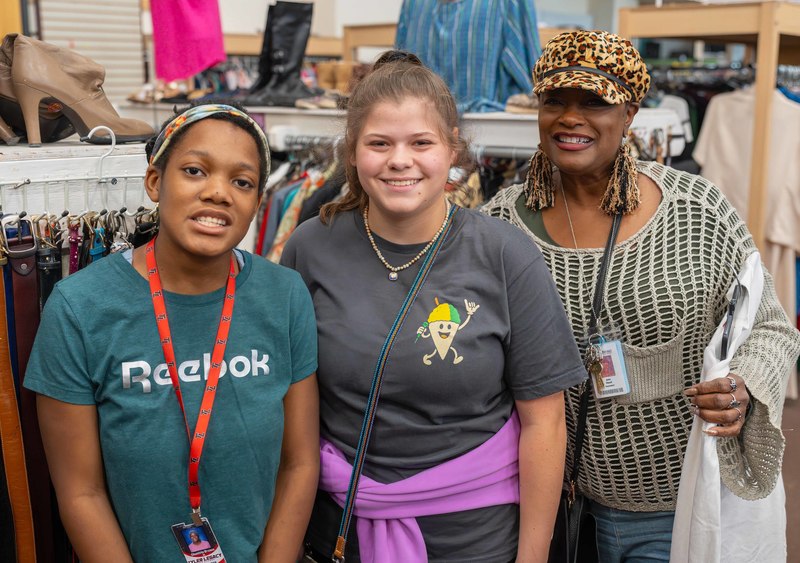 teen girls and woman in clothing store