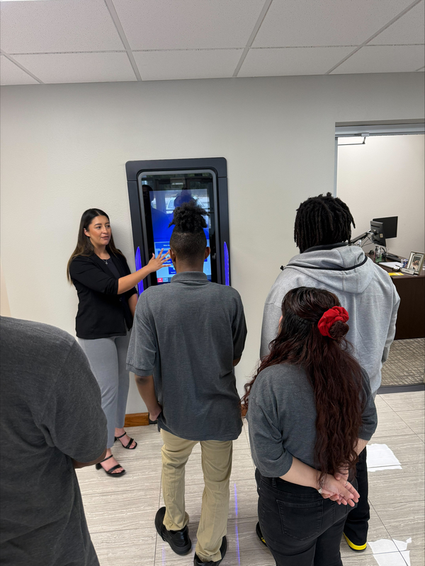 woman teaching teens how to use ATM