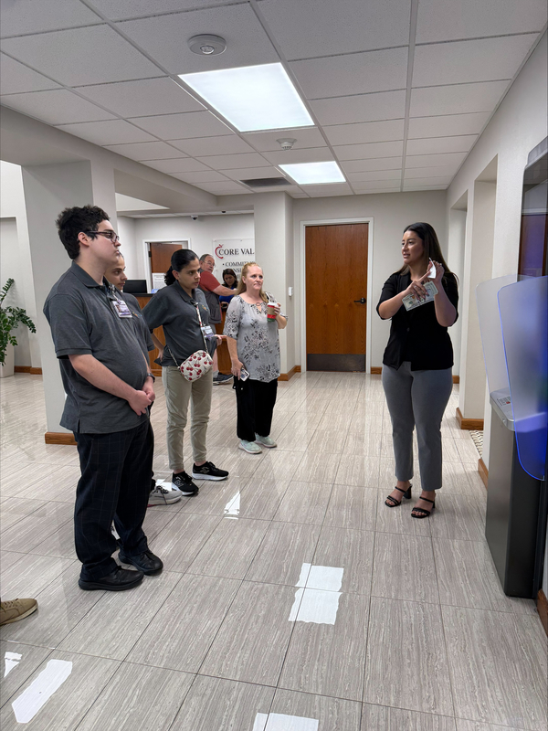 woman talking to teens at bank