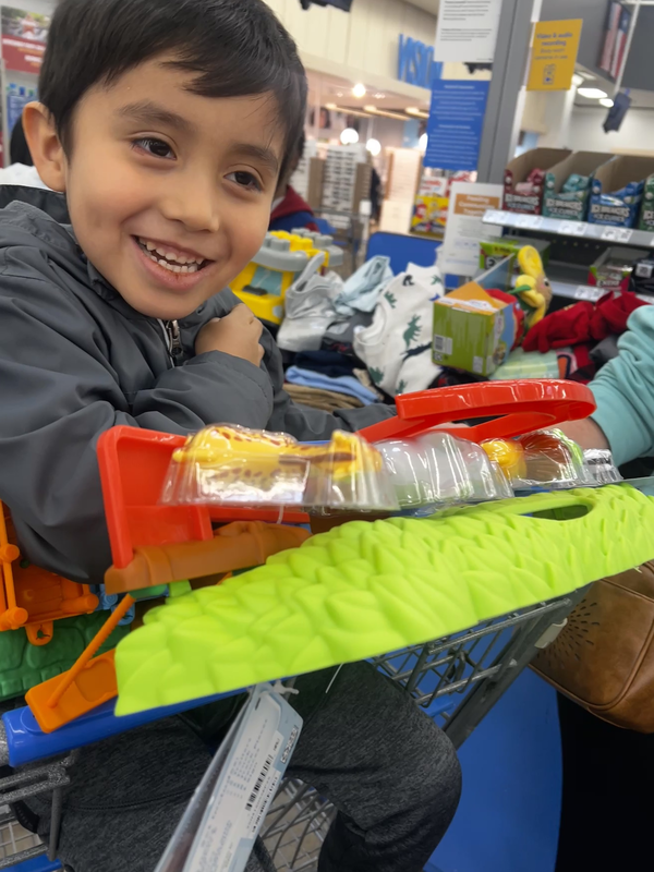 young boy smiling and holding toys