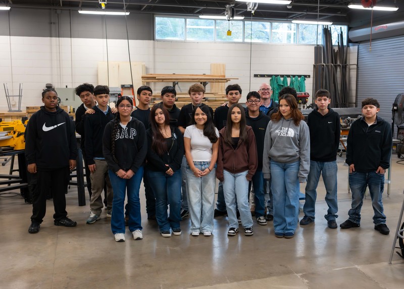 group of teen boys and girls in shop class