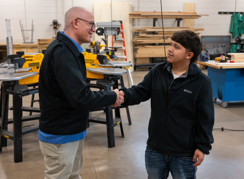 man and teen boy shaking hands