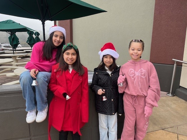 elementary age girls wearing Santa hats