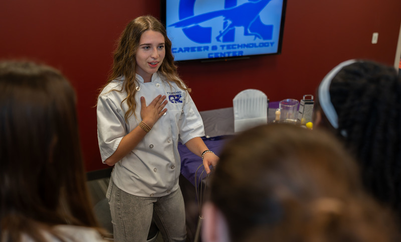 teen girl talking to group of students