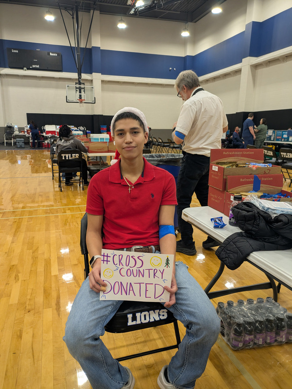 teen boy holding sign that he donated blood